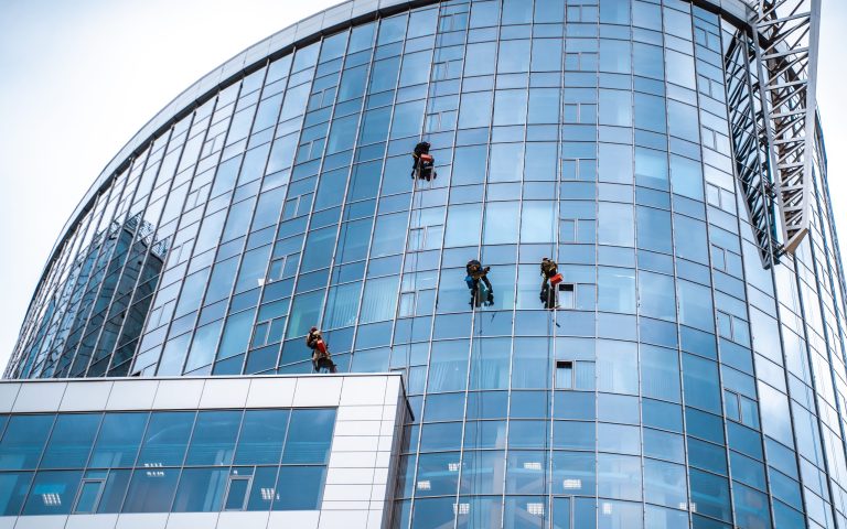 Several workers washing windows in the office building